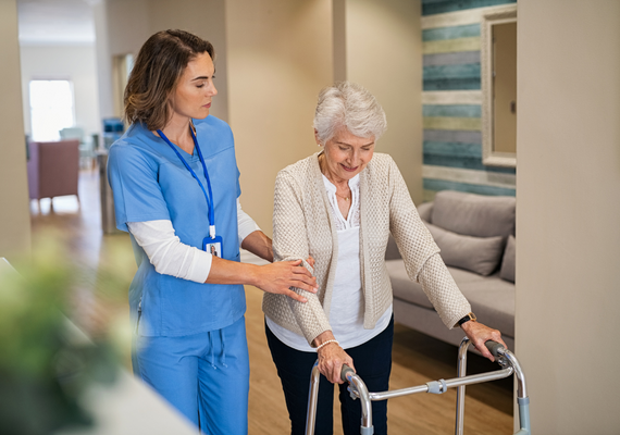 Imagen de una enfermera ayudando a una paciente mayor de edad